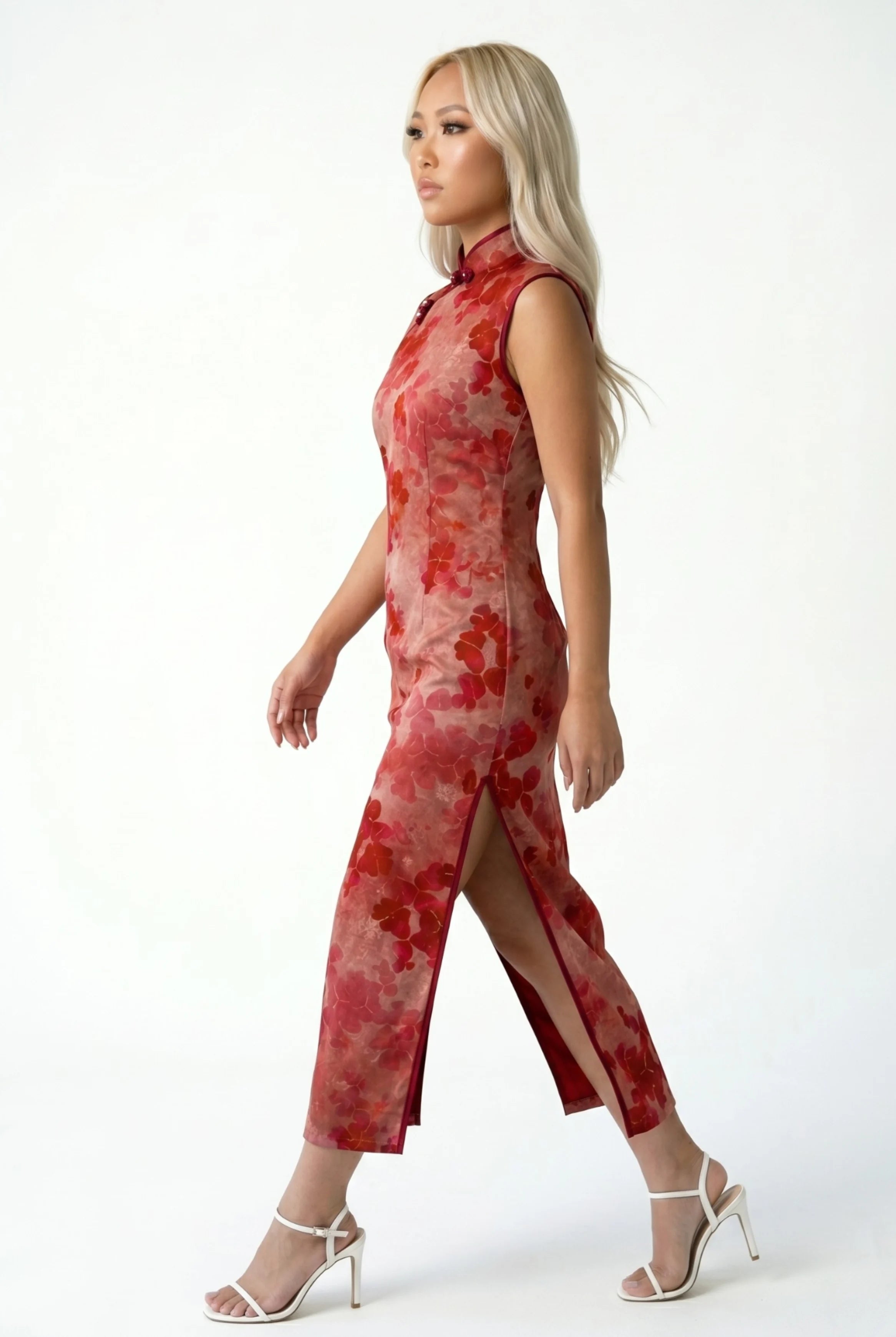 Side view of a woman walking in a red floral qipao, highlighting the side slit.