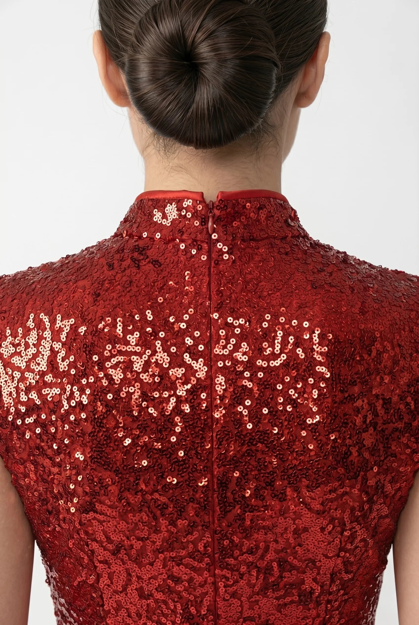 Close-up back view highlighting the high mandarin collar and sleek zipper closure on the red sequin fabric.