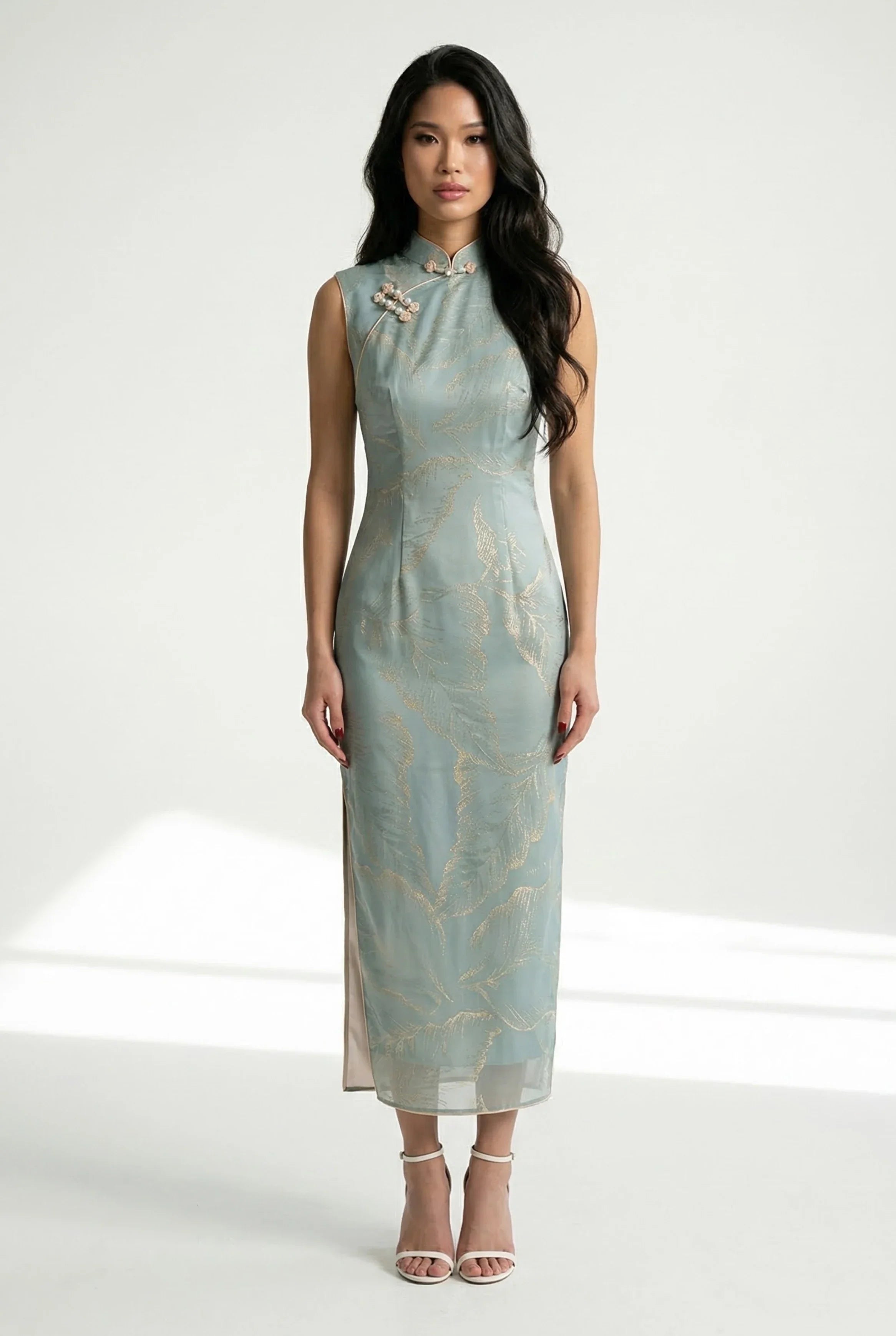 Full-length front view of an elegant sage blue sleeveless Qipao dress with delicate gold leaf patterns and a mandarin collar.