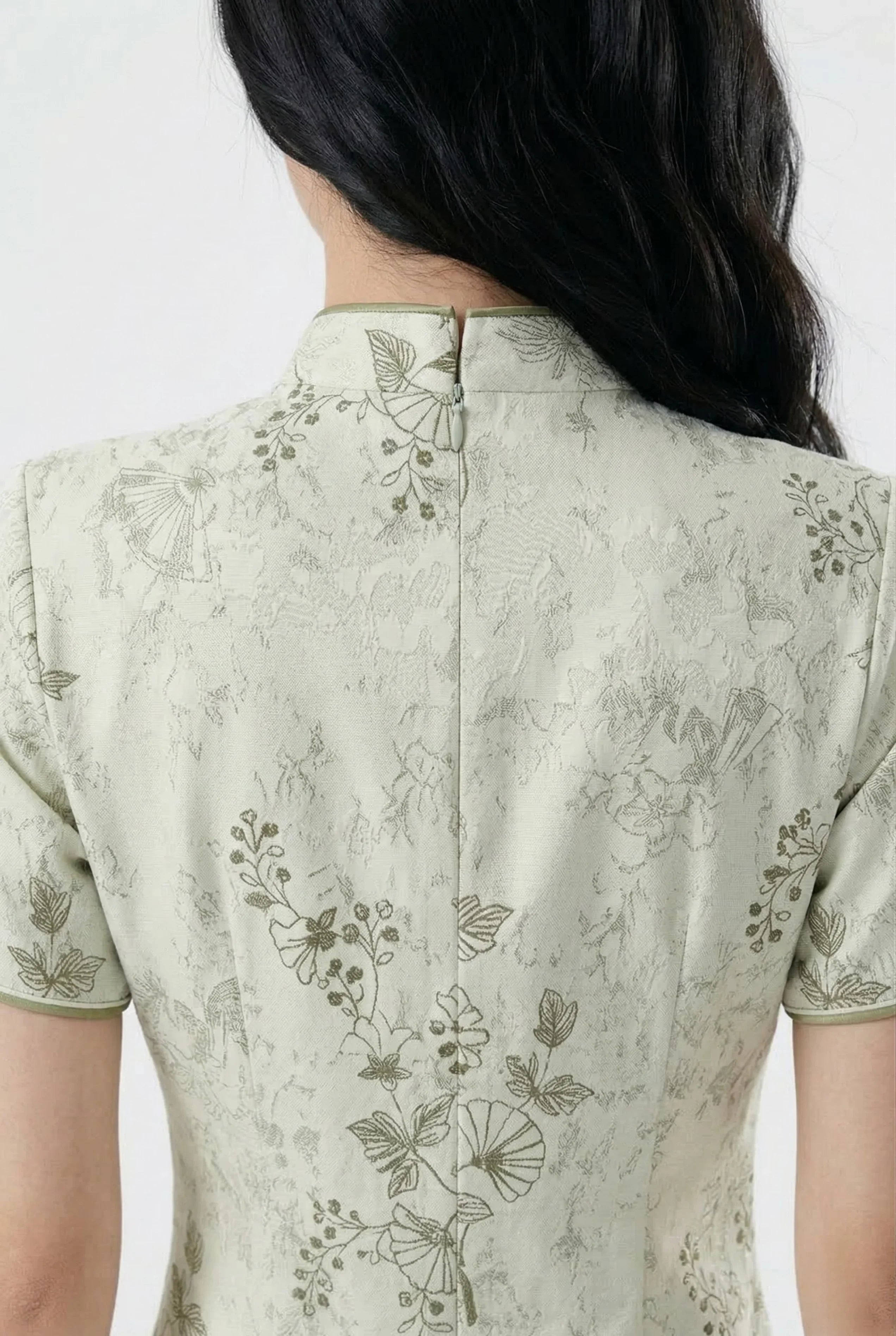 Detail view of the back collar and zipper of the short floral cheongsam.