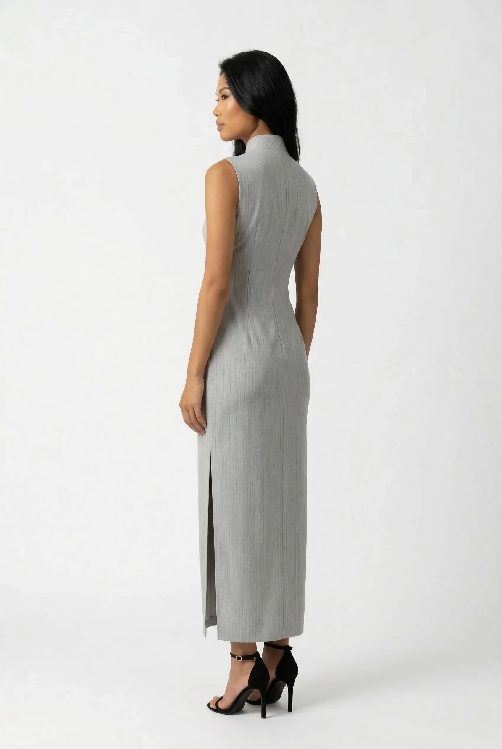 Side profile of a sleeveless grey Chinese dress highlighting the high side slit and elegant drape.