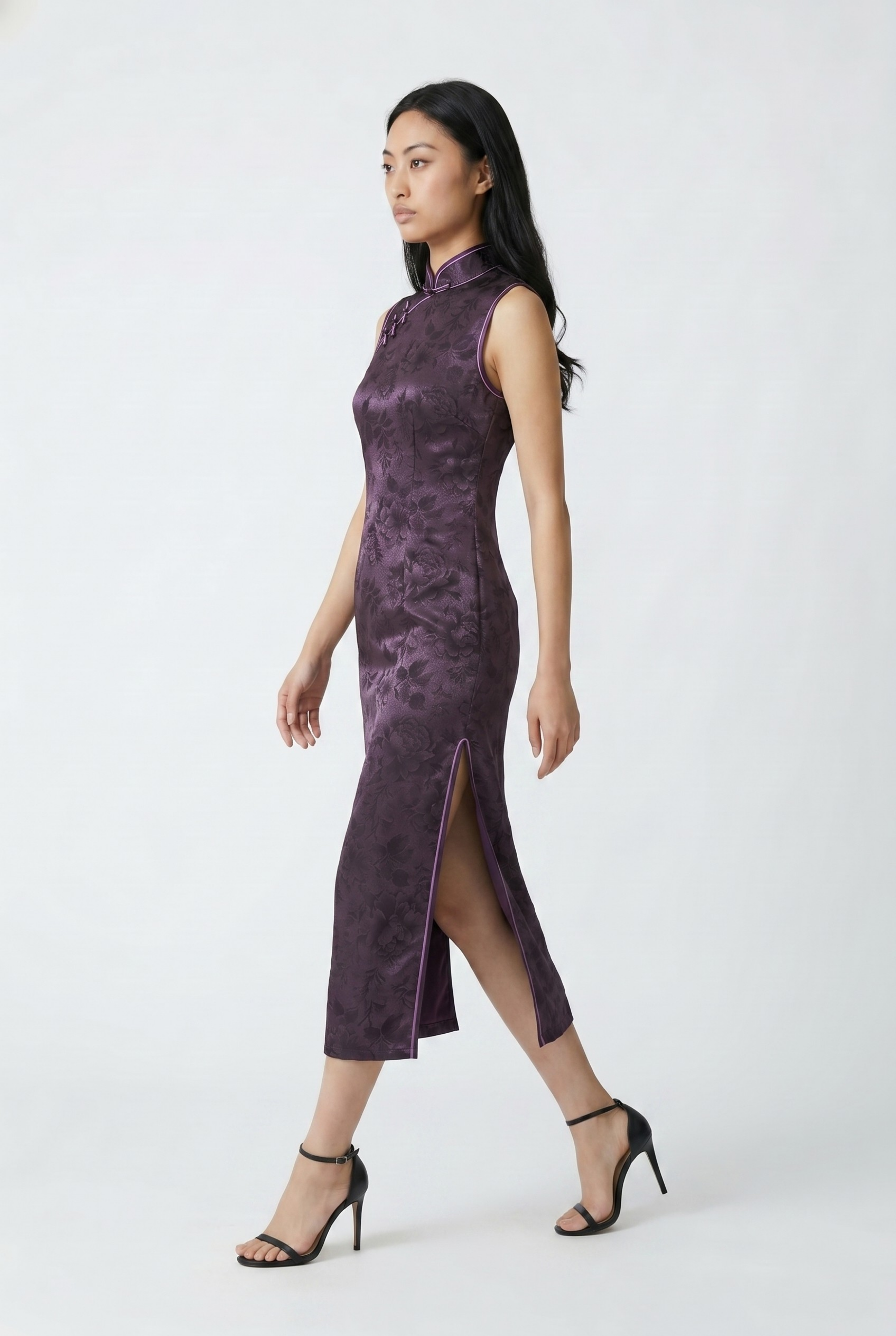 Side profile view of a woman walking in the solid purple qipao dress, showcasing the high side slit