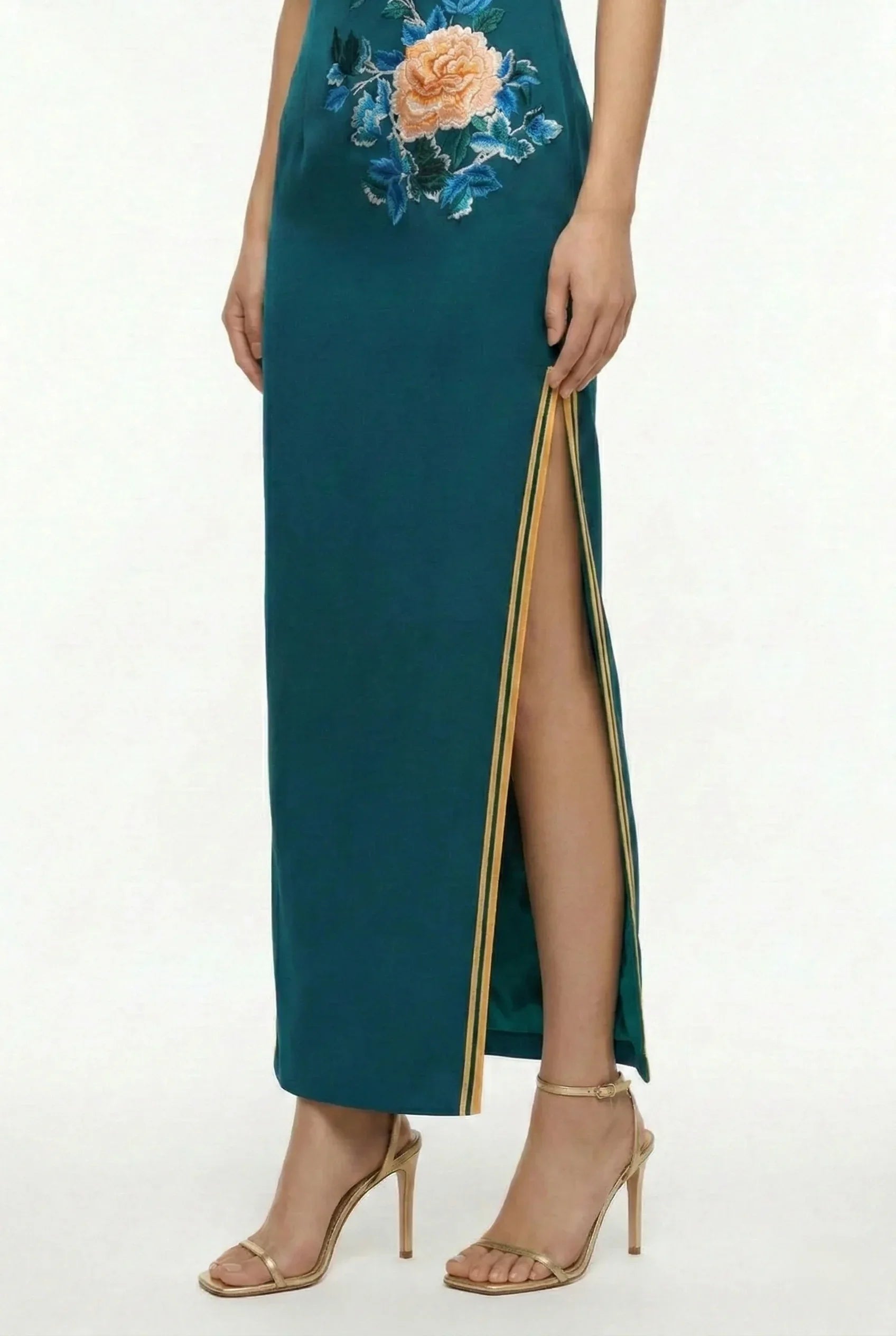 Close-up of side slit with gold border on a teal qipao
