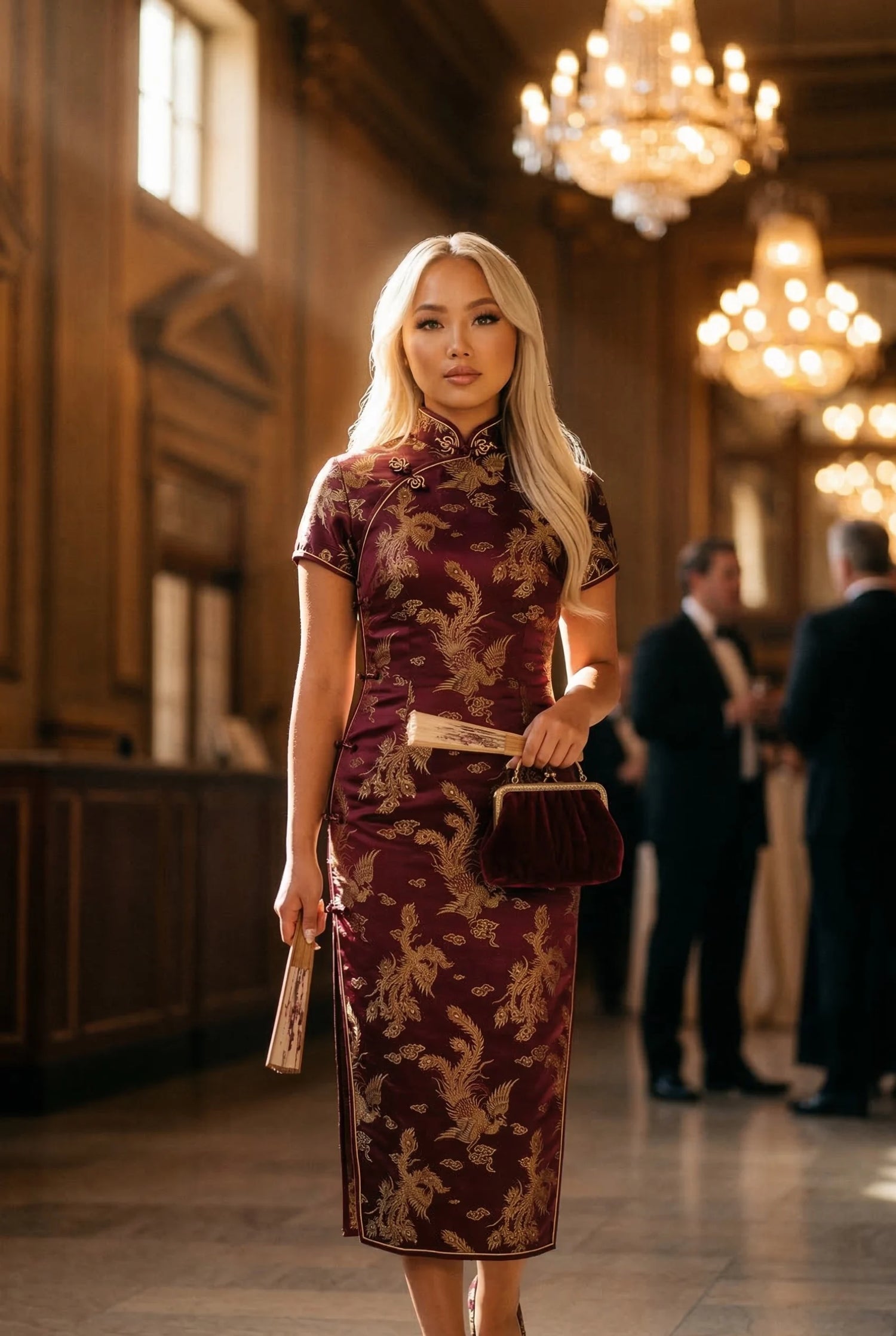 Model wearing a burgundy vintage style chinese dress with gold embroidery at a formal social event, featuring historical accuracy and modern side-zippers by Maison Hua