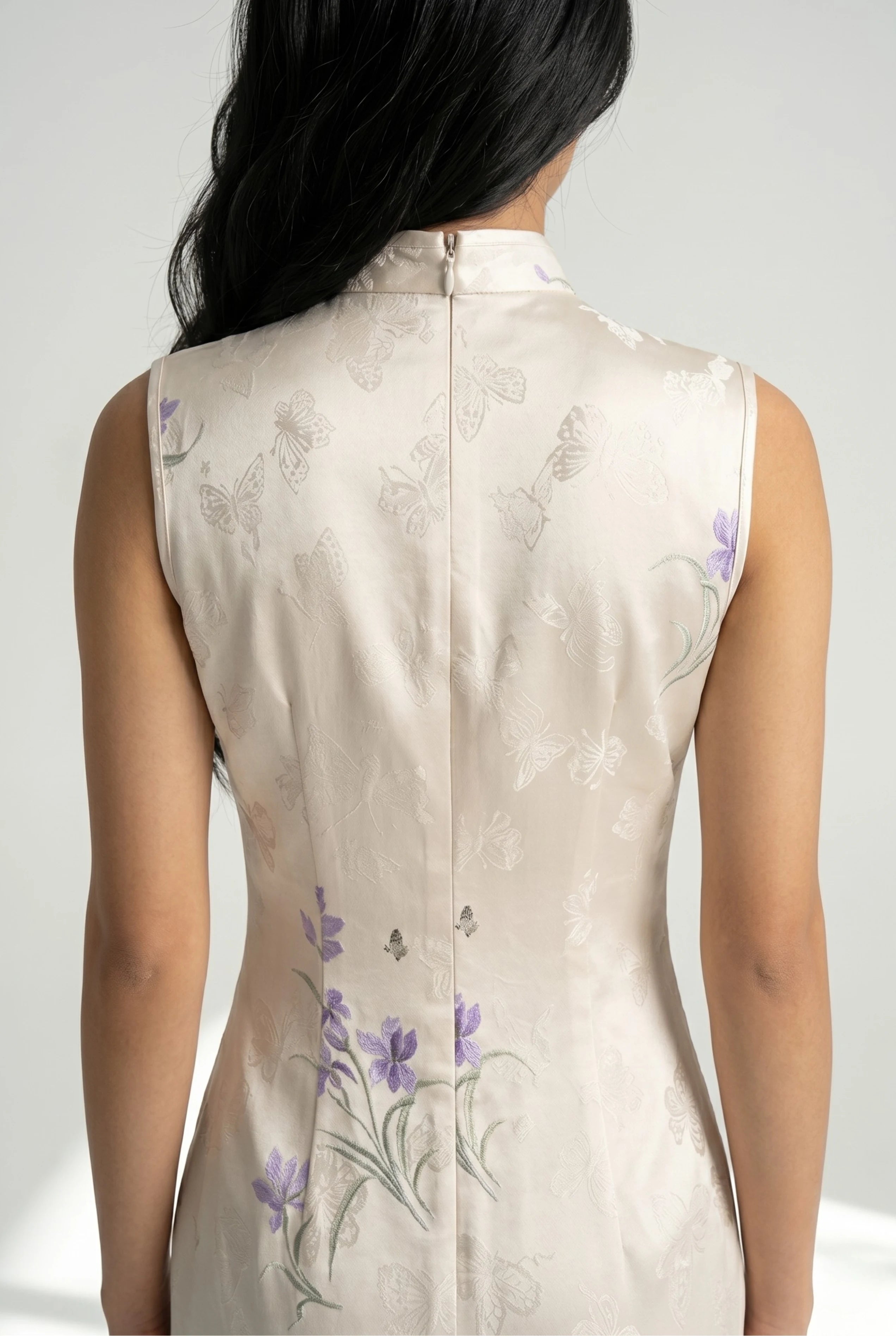 Close-up back view showing the hidden zipper closure and high collar structure of the white cheongsam dress