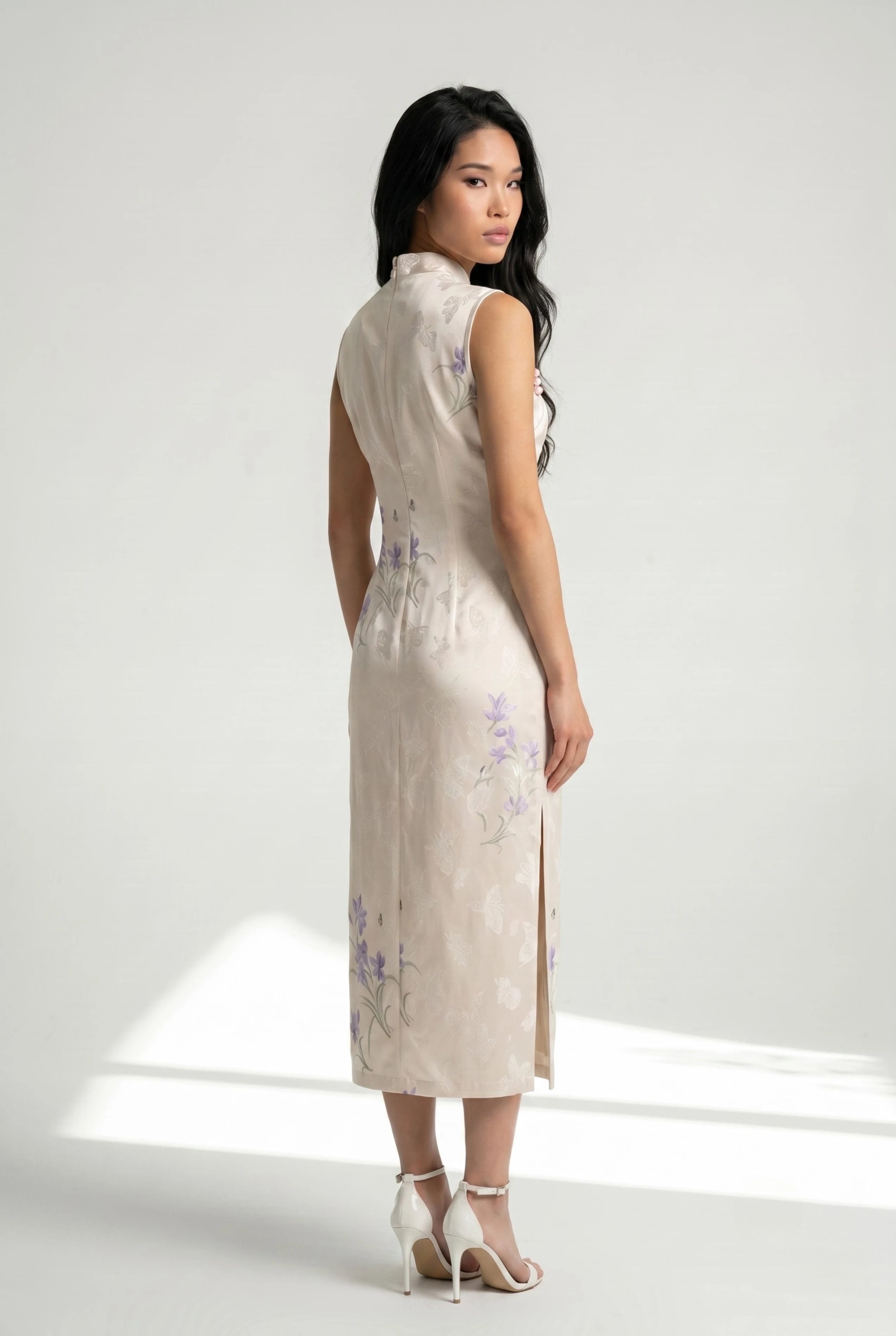 Three-quarter back profile view highlighting the form-fitting design and side slit of the white cheongsam dress