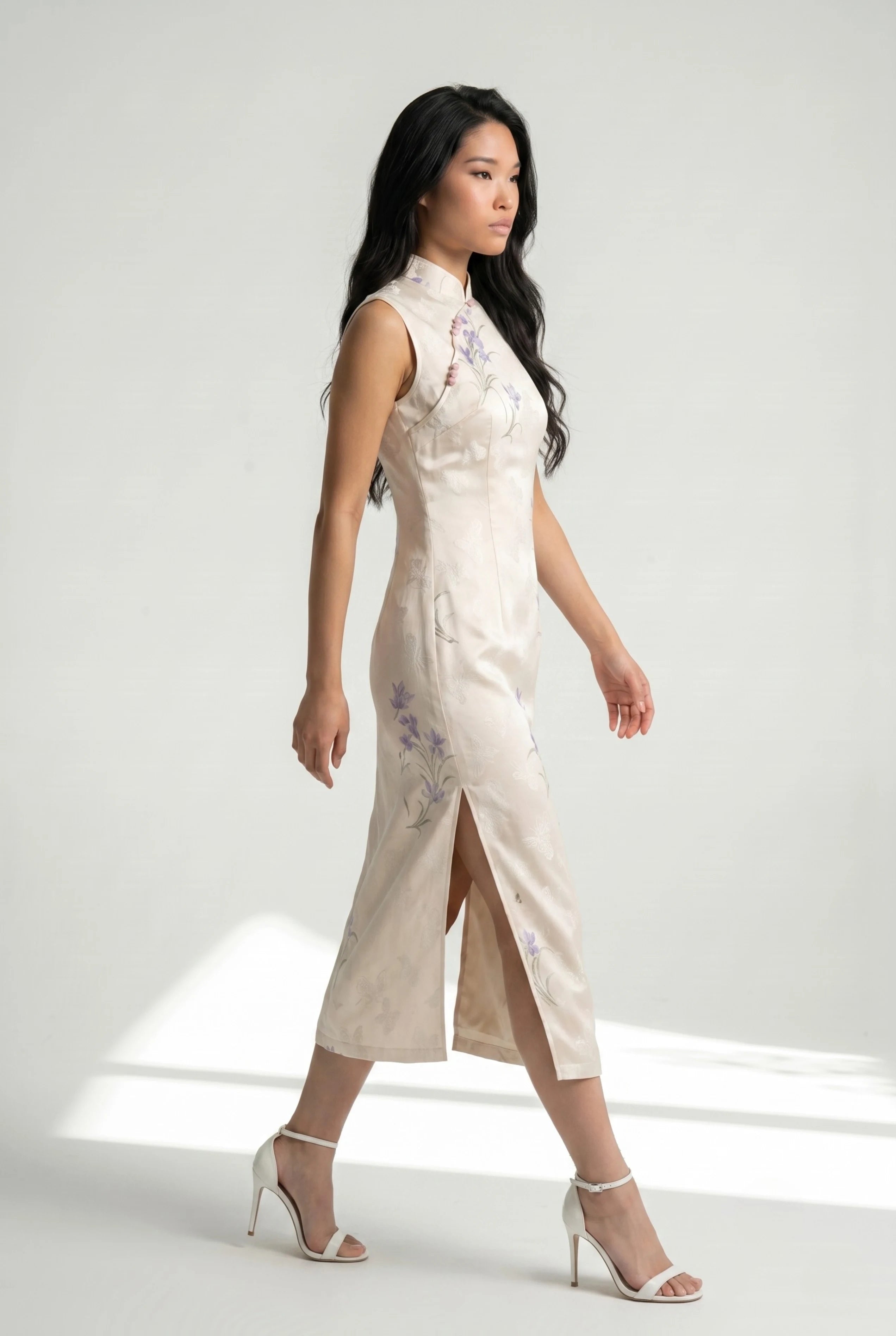 Side profile view of a woman walking in the white Chinese style dress, showcasing the high side slit