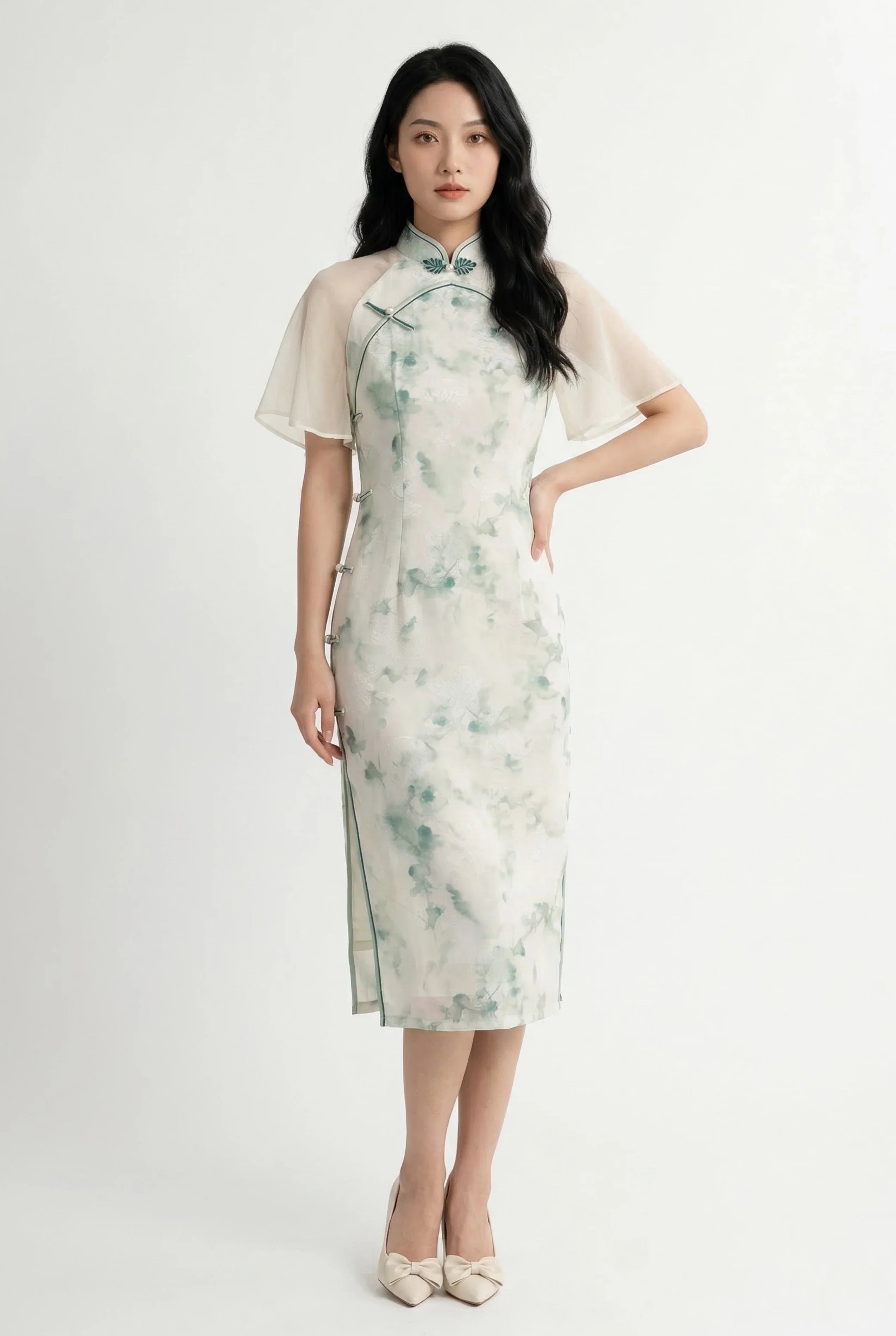Full-length front view of a white and green watercolor floral Qipao dress featuring sheer chiffon cape sleeves.