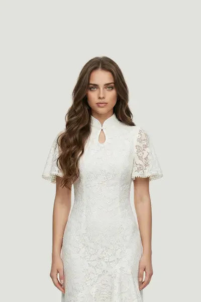 A model wearing a white lace bridal qipao by Maison Hua, featuring elegant flutter sleeves, a keyhole neckline, and a traditional mandarin collar for a modern wedding look