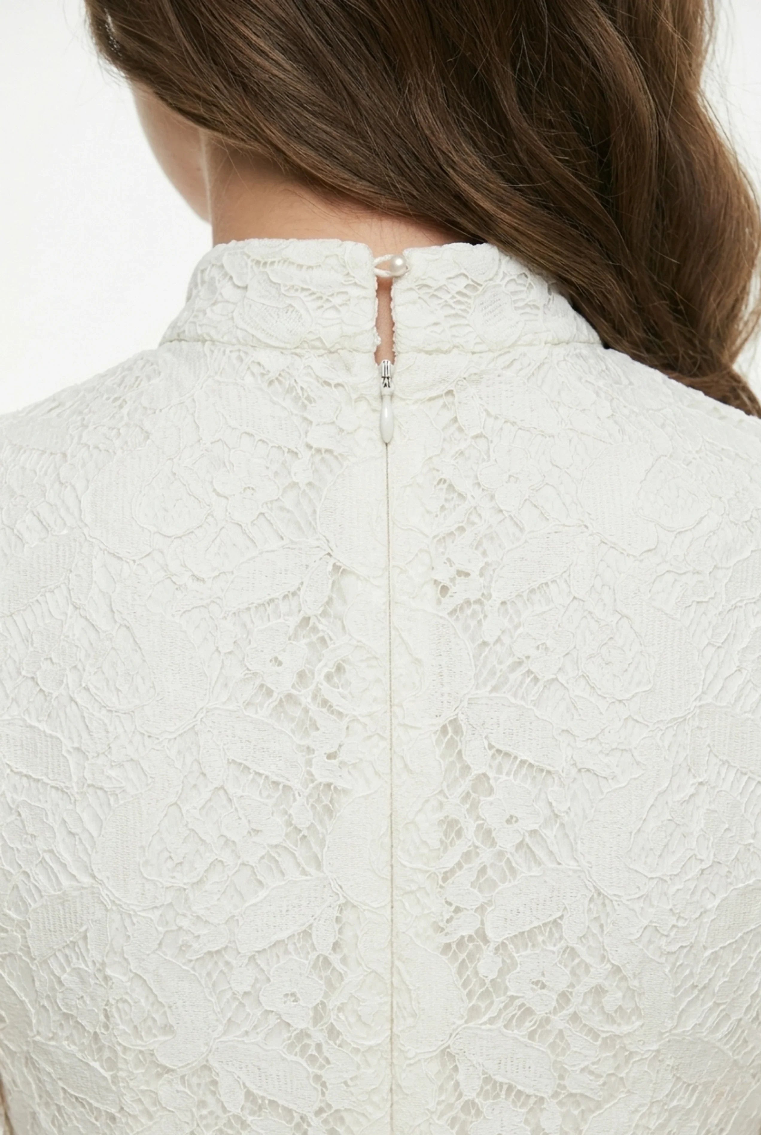Close-up of the back neck and invisible zipper on a white lace cheongsam