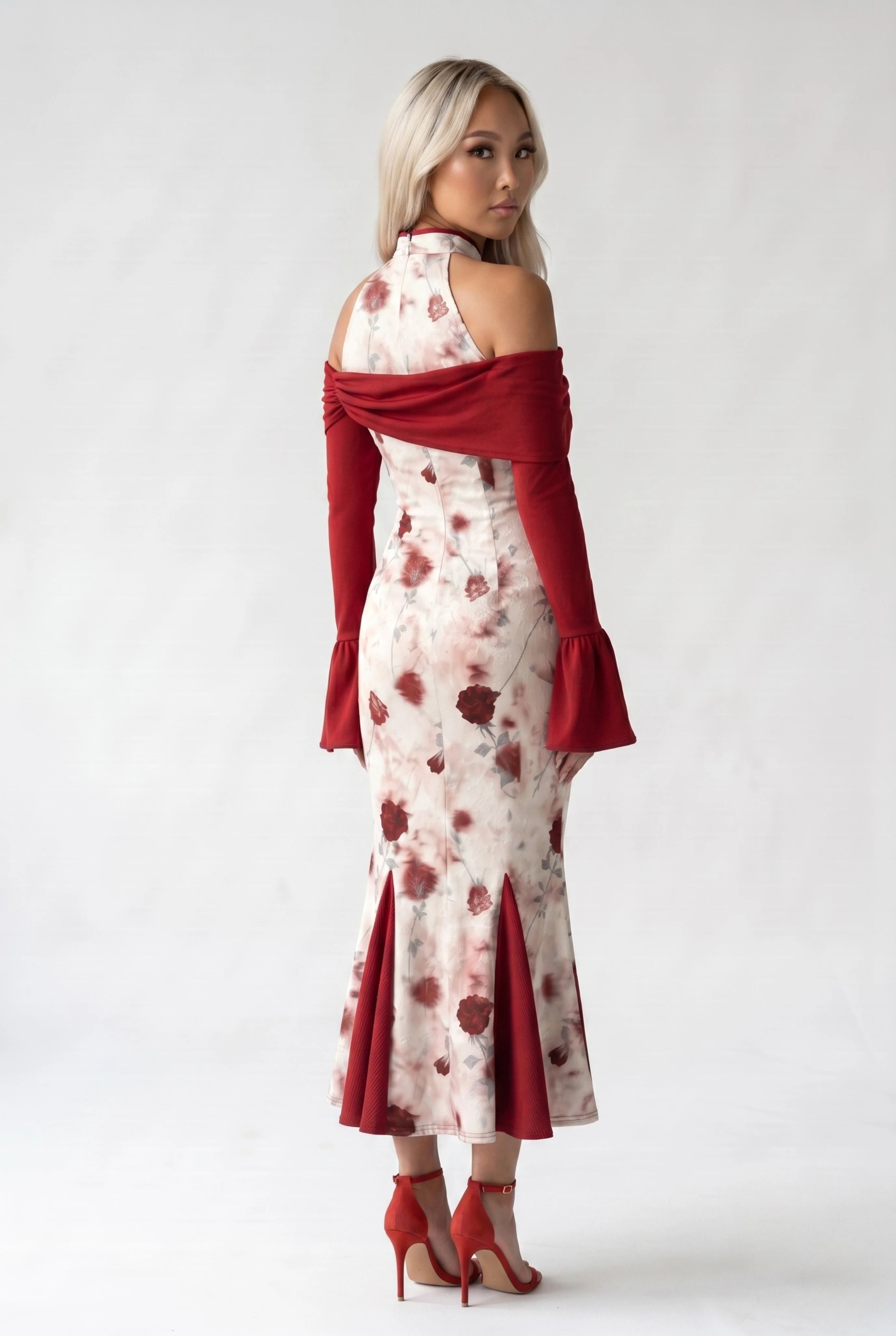 Three-quarter back profile view highlighting the unique flared mermaid panel skirt and the cold-shoulder silhouette