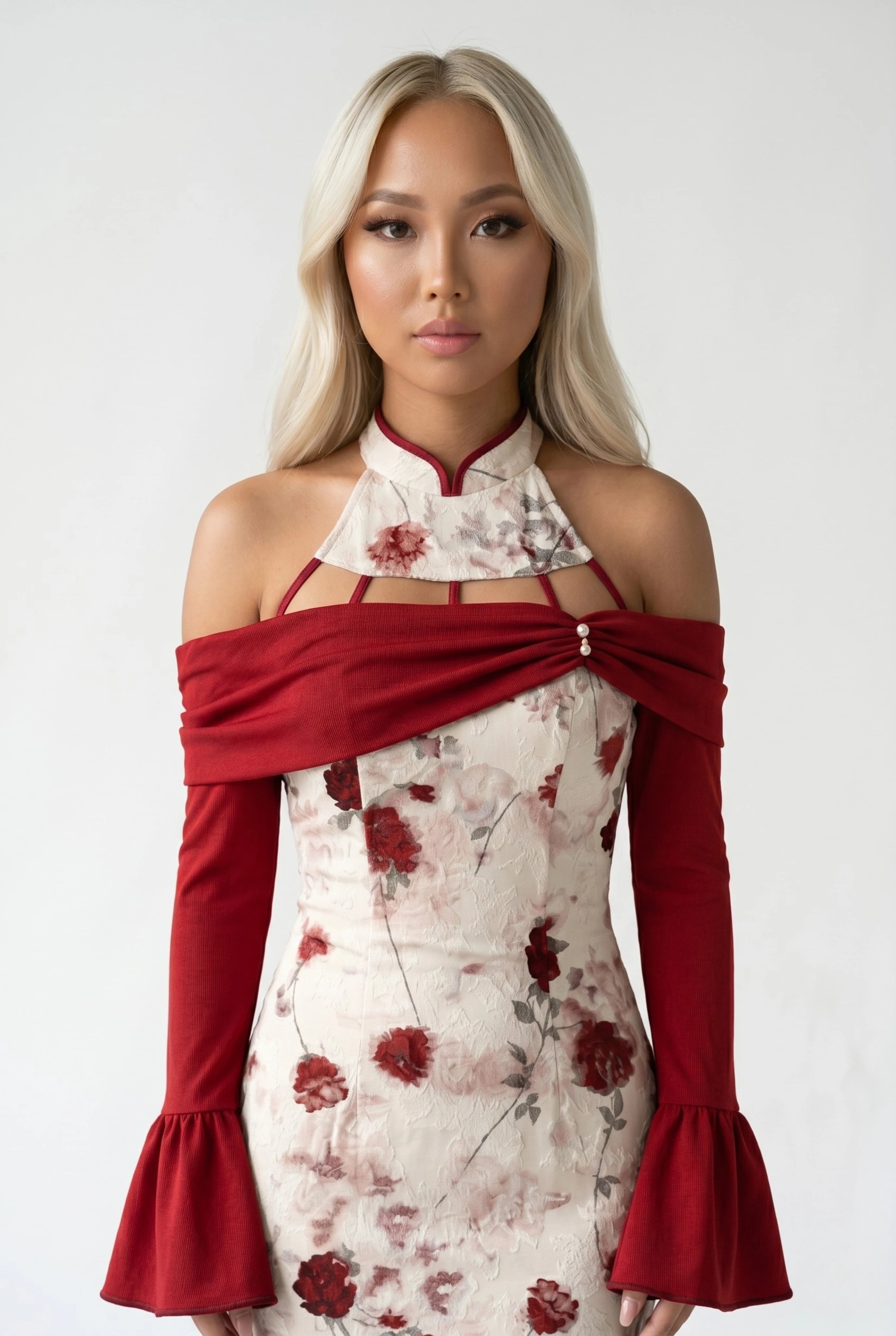 Close-up front view highlighting the high collar, interlocking red neck straps, and draped off-the-shoulder sleeves