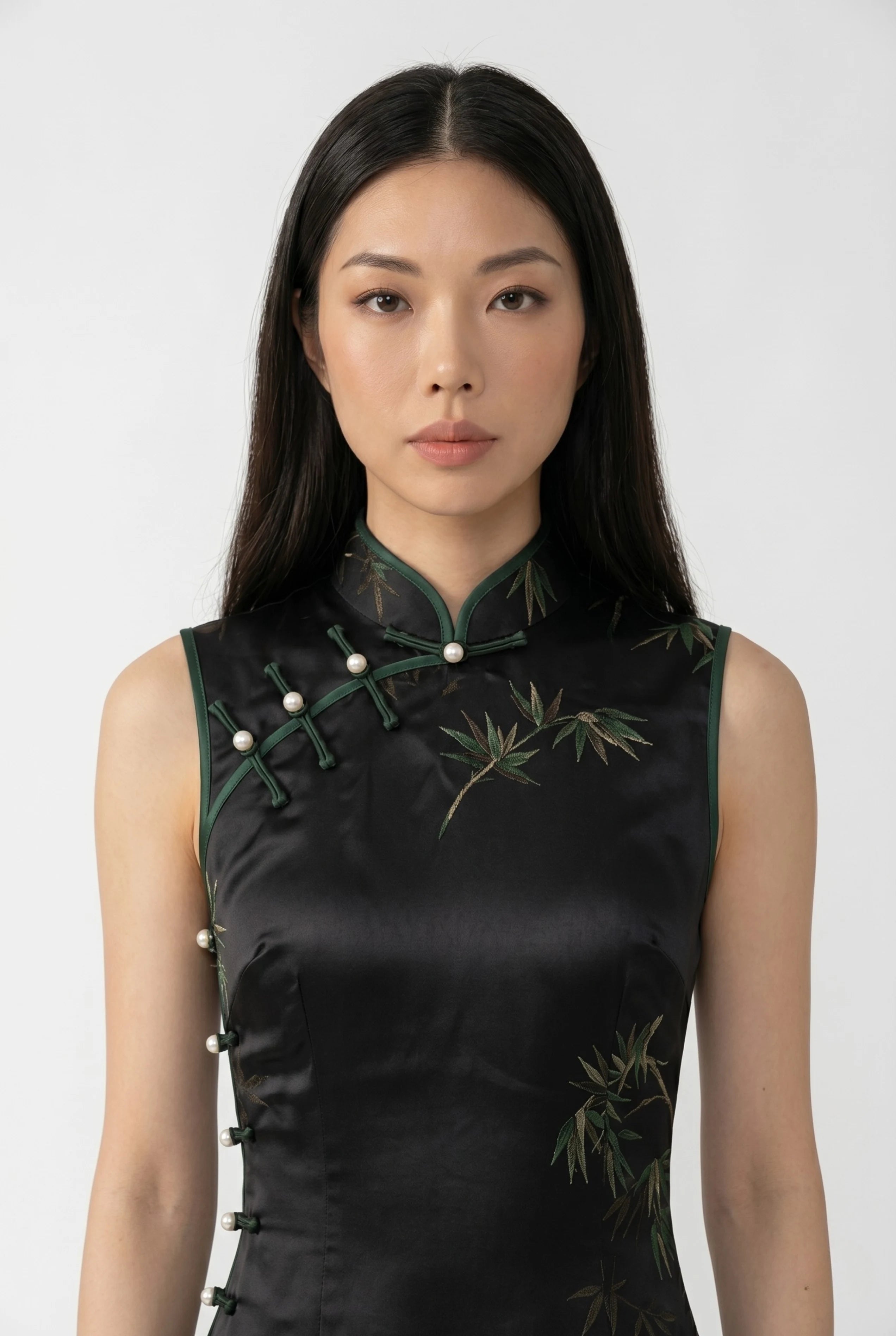 Close-up front view highlighting the high mandarin collar, green trim, and traditional white pearl buttons on the black bodice