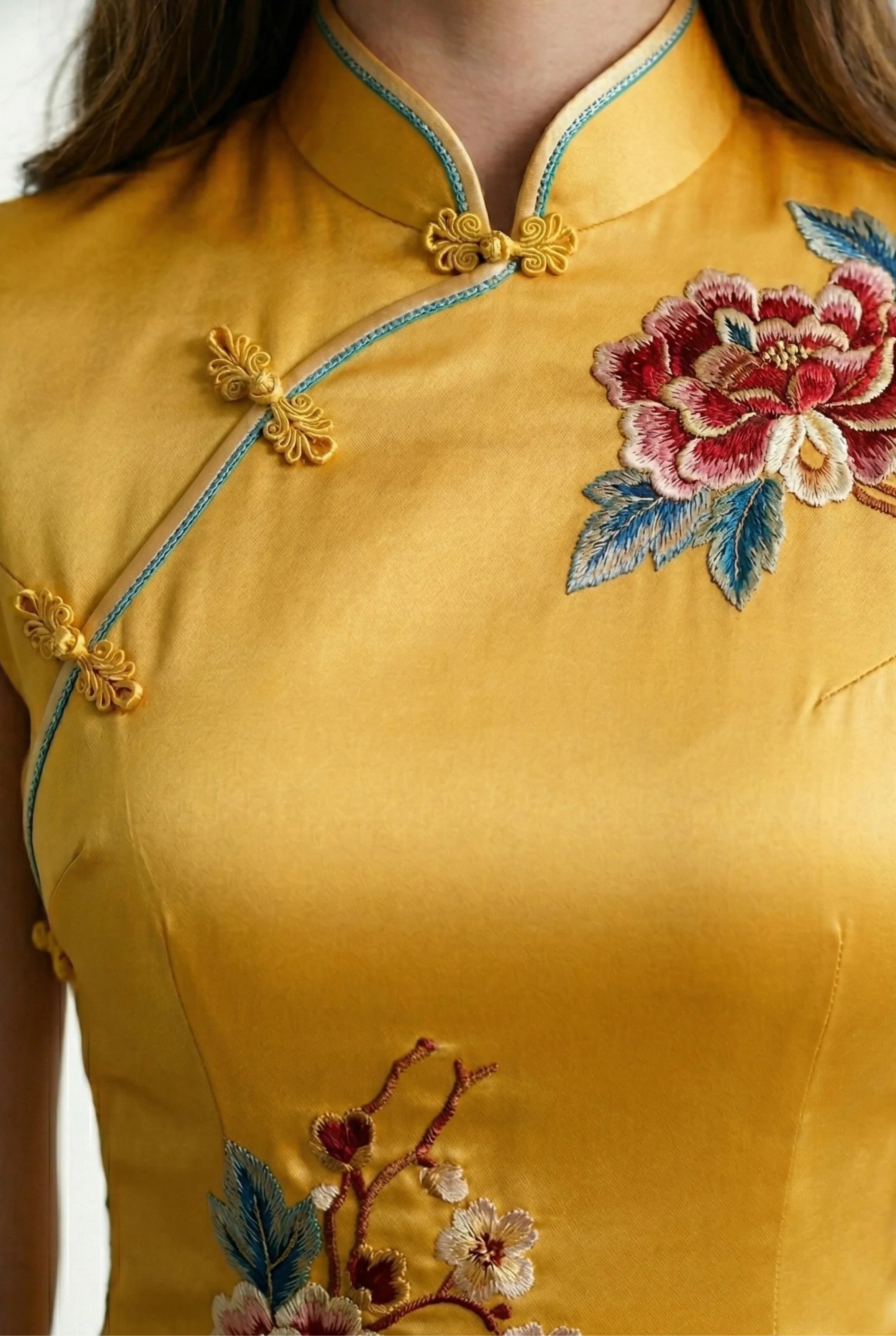 Close-up of the mandarin collar and floral embroidery on the yellow dress.