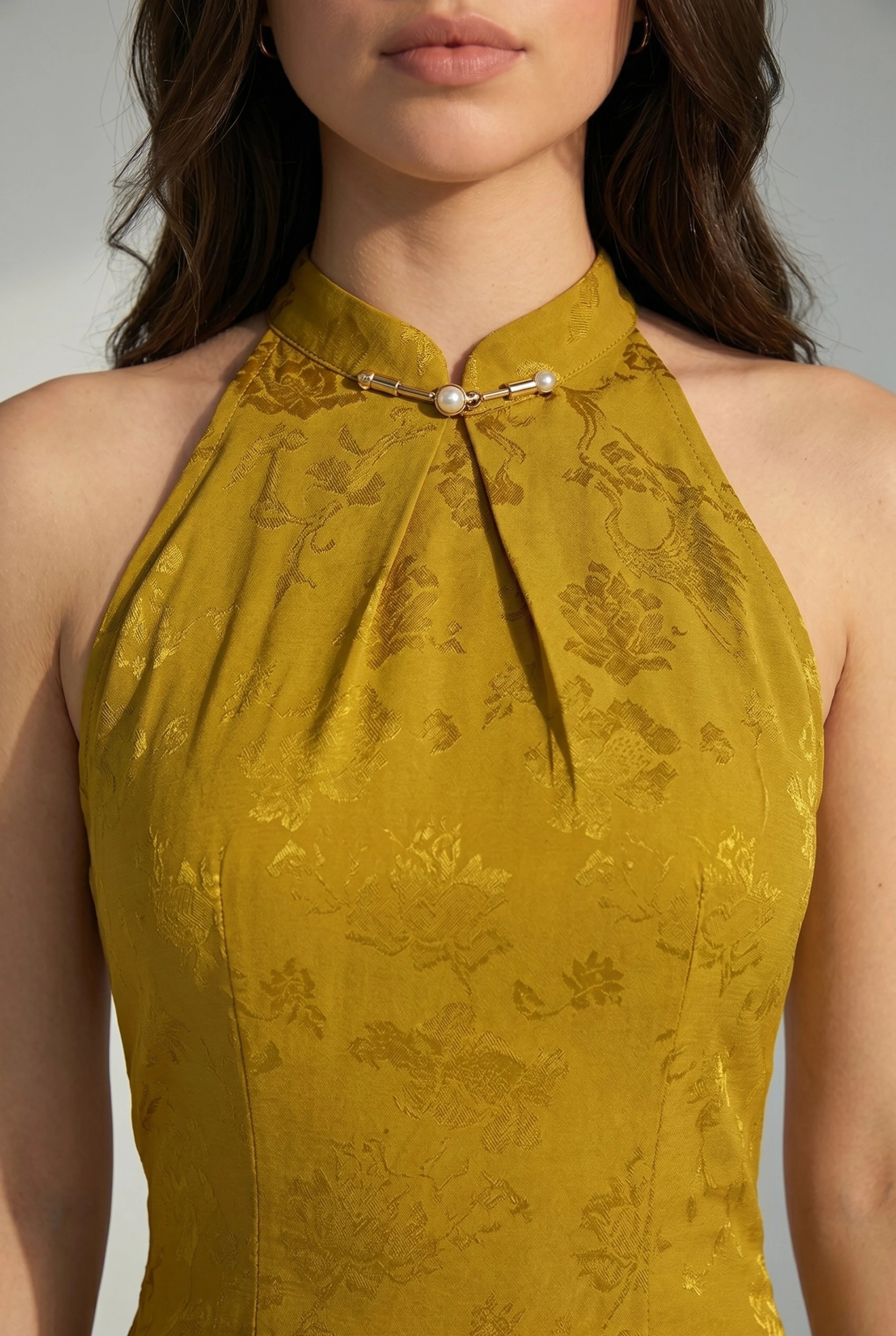 Close-up front view of the high halter neckline with a keyhole opening and traditional metallic closure detail
