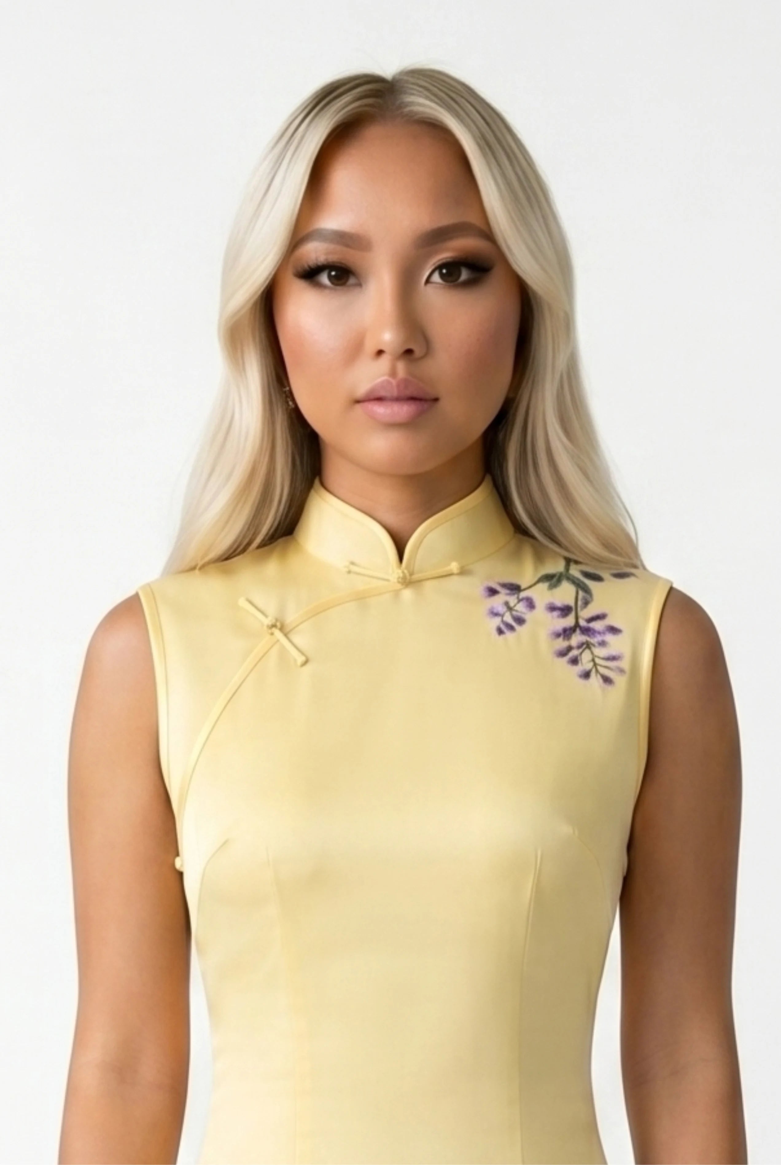 Close-up front view highlighting the high mandarin collar and delicate purple floral embroidery on the shoulder of the yellow qipao