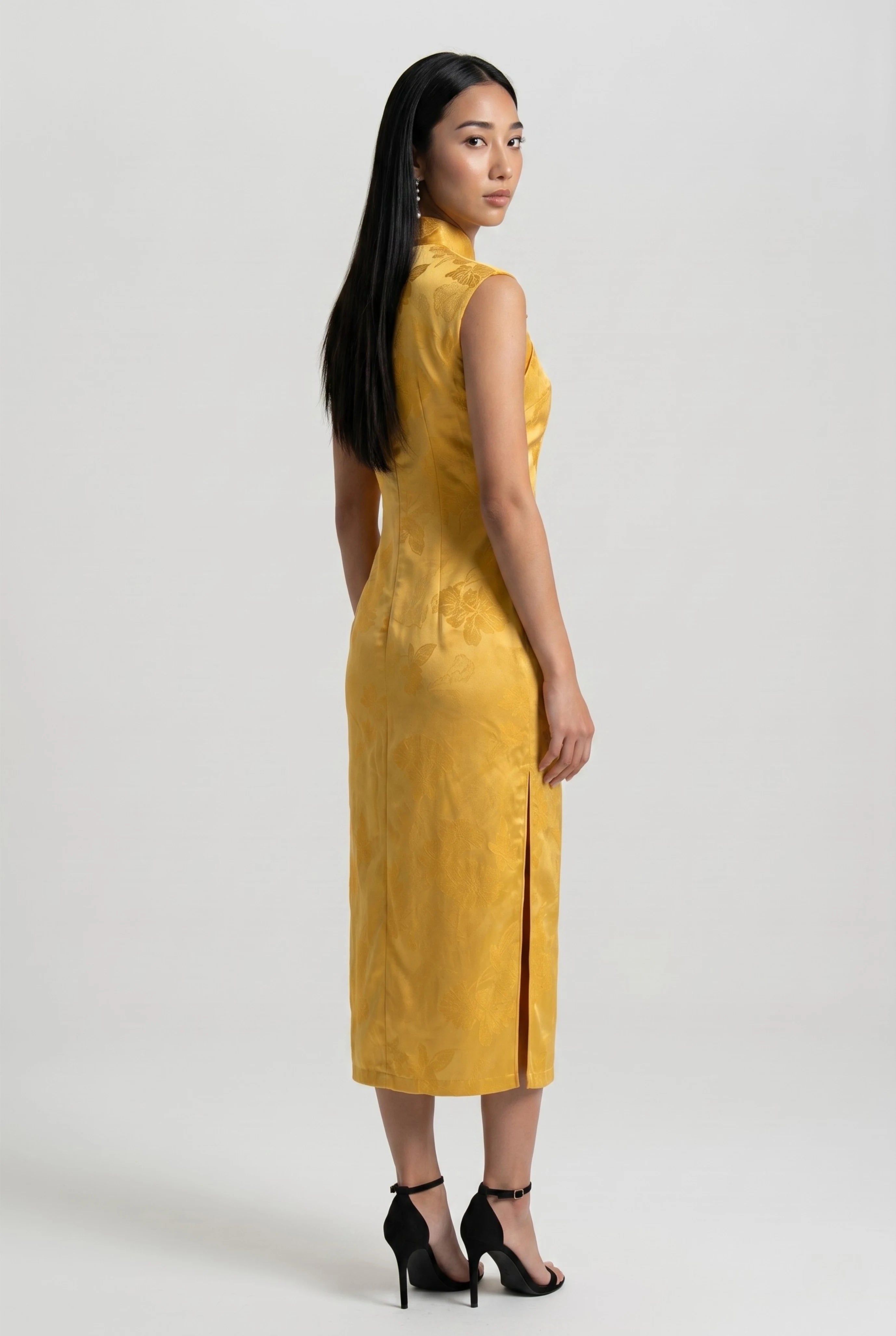 Three-quarter back profile view highlighting the form-fitting design of the yellow velvet cheongsam